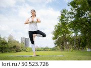 Young female with outdoor activities in the city park, Yoga is her chosen activity. Стоковое фото, агентство Ingram Publishing / Фотобанк Лори