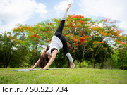 Young female with outdoor activities in the city park, Yoga is her chosen activity. Стоковое фото, агентство Ingram Publishing / Фотобанк Лори