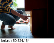 Asian woman checking boxes being transported into new home. Стоковое фото, агентство Ingram Publishing / Фотобанк Лори