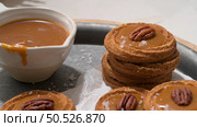 Caramel cookies with pecan nuts served on roud plates, in the kitchen after baking. Стоковое фото, агентство Ingram Publishing / Фотобанк Лори