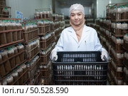 Portrait of a female scientist carrying a box with mushroom lumps in a sterile and temperature-controlled room. Стоковое фото, агентство Ingram Publishing / Фотобанк Лори