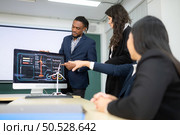 Diverse team of businessmen and engineers consultation on the engineering of a wind turbine that converts wind energy to electricity in the office. Стоковое фото, агентство Ingram Publishing / Фотобанк Лори