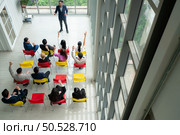 Top view of a group of business people sitting and listening to a presentation in a conference hall. Стоковое фото, агентство Ingram Publishing / Фотобанк Лори