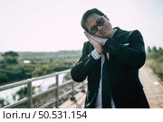 Young Asian Businessman wearing suit with tie and glasses close his eyes with tired and sleeping for relaxing at outdoors. Стоковое фото, агентство Ingram Publishing / Фотобанк Лори