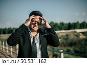Young Asian Businessman wearing suit and tie with eyeglasses with problems and stress outside corporate office. Стоковое фото, агентство Ingram Publishing / Фотобанк Лори