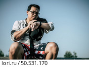 Young Asian Businessman wearing shirt and tie with shorts and eyeglasses with problems and stress or disappointment of work at outside corporate office. Стоковое фото, агентство Ingram Publishing / Фотобанк Лори