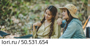 Young female photographer enjoy to take photo her friends, she use digital camera and lovely girl pose at camping tent in nature forest, copy space. Стоковое фото, агентство Ingram Publishing / Фотобанк Лори