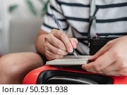 Close-up of man checks the checklist. He’s choosing clothes, travel documents, the itinerary for a solo trip. Travel, holiday and vacation concept. Стоковое фото, агентство Ingram Publishing / Фотобанк Лори