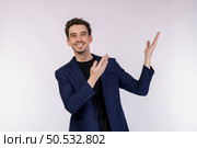Portrait of happy smiling young businessman presenting and showing your text or product isolated on white background. Empty copyspace area for slogan or advertising text message. Стоковое фото, агентство Ingram Publishing / Фотобанк Лори