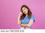 Portrait of young woman wearing casual t-shirt thinking and imagination isolated over pink background. Expression, people and lifestyle concept. Стоковое фото, агентство Ingram Publishing / Фотобанк Лори