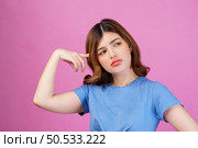 Portrait of young woman wearing casual t-shirt thinking and imagination isolated over pink background. Expression, people and lifestyle concept. Стоковое фото, агентство Ingram Publishing / Фотобанк Лори