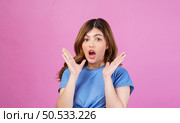 Portrait of excited young woman wearing casual t-shirt surprising isolated over pink background. Expression, people and lifestyle concept. Стоковое фото, агентство Ingram Publishing / Фотобанк Лори