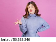 Portrait of confused young woman shrugging shoulders in bewilderment, doubting and feeling uncertain, don’t know answer. isolated over pink background. Emotion concept. Стоковое фото, агентство Ingram Publishing / Фотобанк Лори