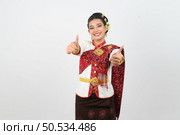 Portrait young pretty woman dress up in beautiful  local culture in northern region with gladtful posture, smile and thumb up on white background, copy space. Стоковое фото, агентство Ingram Publishing / Фотобанк Лори