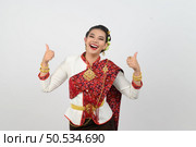 Portrait young pretty woman dress up in beautiful  local culture in northern region with gladtful posture, smile and thumb up on white background, copy space. Стоковое фото, агентство Ingram Publishing / Фотобанк Лори