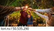 Portrait of Happy Asian group of friends having fun with sparklers outdoor - Young people having fun with fireworks at night time  - People, food, drink lifestyle, new year celebration concept. Стоковое фото, агентство Ingram Publishing / Фотобанк Лори