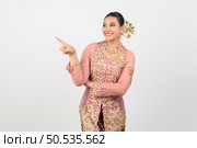 Portrait Young beautiful woman dress up in local culture in southern region with charming gesture smile and point finger on white background, copy space. Стоковое фото, агентство Ingram Publishing / Фотобанк Лори