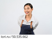 Portrait Asian young woman in waitress uniform standing and smile with happy, Free space to insert product for advertising, isolated on white background. Стоковое фото, агентство Ingram Publishing / Фотобанк Лори