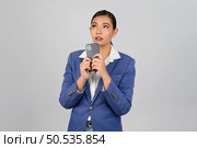 Portrait Asian young woman in officer uniform standing with mobile phone in hand posture, Cheerful girl with happy smiling during use smartphone, isolated on white background. Стоковое фото, агентство Ingram Publishing / Фотобанк Лори
