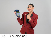 Portrait Asian young woman in officer uniform point finger exciting to showing credit card and payment machine, copy space for insert advertising your product, isolated on white background. Стоковое фото, агентство Ingram Publishing / Фотобанк Лори