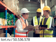 Before exporting to other nations, The product owner meets with the foreman and warehouse personnel to verify their own items held at this warehouse. Стоковое фото, агентство Ingram Publishing / Фотобанк Лори