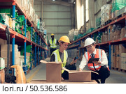 Before exporting to other nations, The product owner meets with the foreman and warehouse personnel to verify their own items held at this warehouse. Стоковое фото, агентство Ingram Publishing / Фотобанк Лори