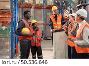Managers, foremen and warehouse workers Consult together about getting the goods out of the warehouse to finish sending the small merchants tonight. Стоковое фото, агентство Ingram Publishing / Фотобанк Лори