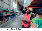 Portrait of warehouse workers in a large warehouse with their own preparation for the day’s work. Стоковое фото, агентство Ingram Publishing / Фотобанк Лори