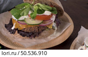 Healthy vegan burger with fresh vegetables and yogurt sauce on rustic kitchen counter top. Стоковое фото, агентство Ingram Publishing / Фотобанк Лори
