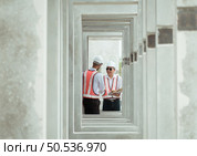 Both of construction engineers verify the constructed precast concrete wall slabs’ quality. also to oversee significant construction projects in the construction zone. Стоковое фото, агентство Ingram Publishing / Фотобанк Лори