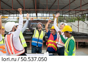 Construction engineers, architects, and foremen form a group. Participate in a meeting to plan new construction projects. Cheers to express happiness that the event was successfully accomplished. Стоковое фото, агентство Ingram Publishing / Фотобанк Лори