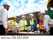 Construction engineers, architects, and foremen form a group. Participate in a meeting to plan new construction projects. Shake hands in thanks for the successful completion of the responsible work. Стоковое фото, агентство Ingram Publishing / Фотобанк Лори