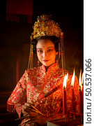 Chinese woman make wishes, pray, and light candles. On the occasion of the annual Chinese New Year festival, in a revered shrine or temple, And in Chinese where candles mean good luck and happiness. Стоковое фото, агентство Ingram Publishing / Фотобанк Лори