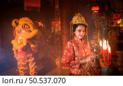 Chinese woman make wishes, pray, and light candles. On the occasion of the annual Chinese New Year festival, in a revered shrine or temple, And in Chinese where candles mean good luck and happiness. Стоковое фото, агентство Ingram Publishing / Фотобанк Лори