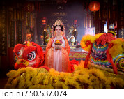 Chinese woman with yellow and red lions It is considered to enhance the prosperity for oneself on the occasion of the Chinese New Year festival every year and in Chinese, it means prosperous, fortunate, happy, prosperous. Стоковое фото, агентство Ingram Publishing / Фотобанк Лори