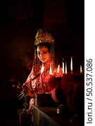 Chinese woman make wishes, pray, and light candles. On the occasion of the annual Chinese New Year festival, in a revered shrine or temple, And in Chinese where candles mean good luck and happiness. Стоковое фото, агентство Ingram Publishing / Фотобанк Лори
