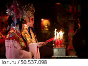 Male and female Chinese opera actors Light a candle to pray homage to the gods to enhance the prosperity for yourself on the occasion of the Chinese New Year festival. Стоковое фото, агентство Ingram Publishing / Фотобанк Лори