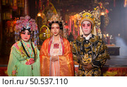 Male and female Chinese opera actors Light a candle to pray homage to the gods to enhance the prosperity for yourself on the occasion of the Chinese New Year festival. Стоковое фото, агентство Ingram Publishing / Фотобанк Лори