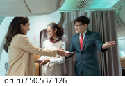 Flight attendant greet passengers as they enter the aircraft to locate a seat in the cabin. Стоковое фото, агентство Ingram Publishing / Фотобанк Лори