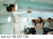 Flight attendants show how to use safety devices and recommend emergency exits. Стоковое фото, агентство Ingram Publishing / Фотобанк Лори