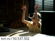 Portrait of little girl in office room of house with gestures that are expressed when playing virtual reality games. Стоковое фото, агентство Ingram Publishing / Фотобанк Лори