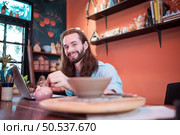 A young businessman owns a small pottery business. Are building themselves by saving money to expand their business in the future. Стоковое фото, агентство Ingram Publishing / Фотобанк Лори