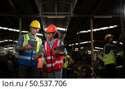 The foreign chief engineer came to inspect the old mechanical factory. There is an African female mechanic explaining details and progress reports on old machines being repaired to restore normal operation. Стоковое фото, агентство Ingram Publishing / Фотобанк Лори