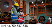 Two technicians Inspecting and testing the operation of lifting cranes in heavy industrial plants. Стоковое фото, агентство Ingram Publishing / Фотобанк Лори