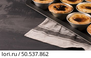 Rows of freshly cooked egg tarts, traditional portuguese dessert, pastel de nata, custard tarts on metal tray. Стоковое фото, агентство Ingram Publishing / Фотобанк Лори