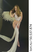 Elegant woman with wings posing in studio setting for artistic shoot. Стоковое видео, видеограф Гурьянов Андрей / Фотобанк Лори