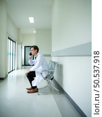 The doctor is using the phone to see the tasks that will be responsible for the day. to provide complete and complete treatment of patients. Стоковое фото, агентство Ingram Publishing / Фотобанк Лори