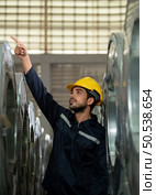 Portrait of a heavy equipment male engineer from a huge industry who came to inspect the metal sheet factory’s machinery. Стоковое фото, агентство Ingram Publishing / Фотобанк Лори