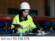 Portrait of a heavy equipment female engineer from a huge industry who came to inspect the metal sheet factory’s machinery. Стоковое фото, агентство Ingram Publishing / Фотобанк Лори