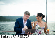 On a yacht, a businessman begins his family’s vacation. a huge project agreement was successfully closed, which was wonderful news. Стоковое фото, агентство Ingram Publishing / Фотобанк Лори